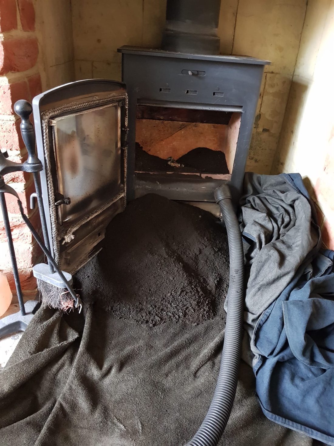 Soot swept from a wood burner onto dust sheets
